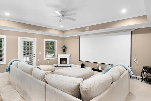 cinema featuring ceiling fan, ornamental molding, and light carpet