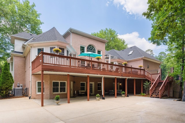 rear view of property featuring a patio, a wooden deck, and central AC