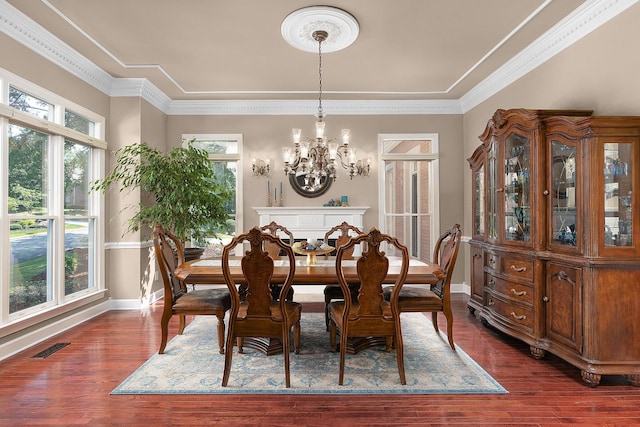 dining area with dark hardwood / wood-style flooring, crown molding, and an inviting chandelier