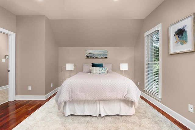 bedroom with lofted ceiling and hardwood / wood-style floors