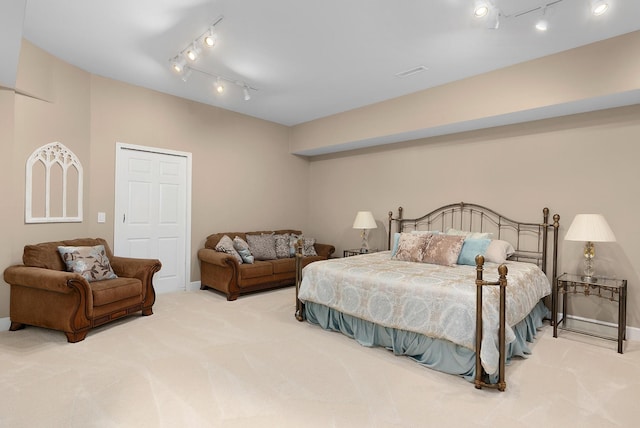 carpeted bedroom featuring track lighting