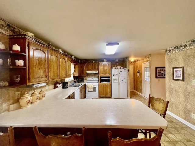 kitchen featuring sink, white appliances, and kitchen peninsula