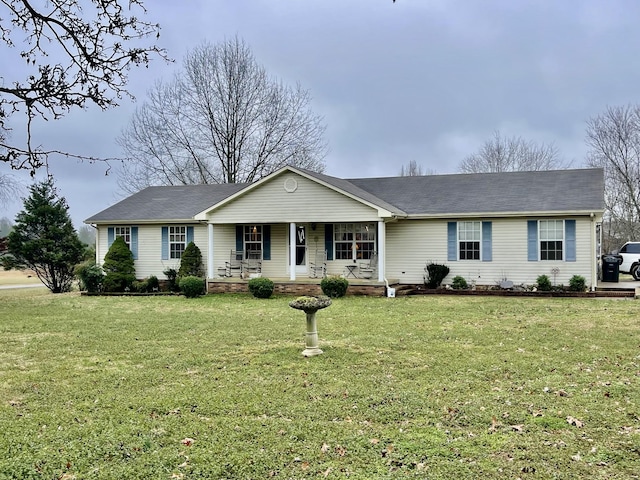 ranch-style house featuring covered porch and a front lawn