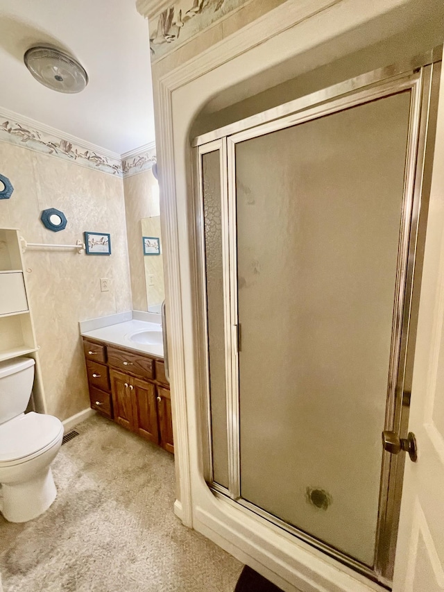 bathroom featuring vanity, toilet, and a shower with door