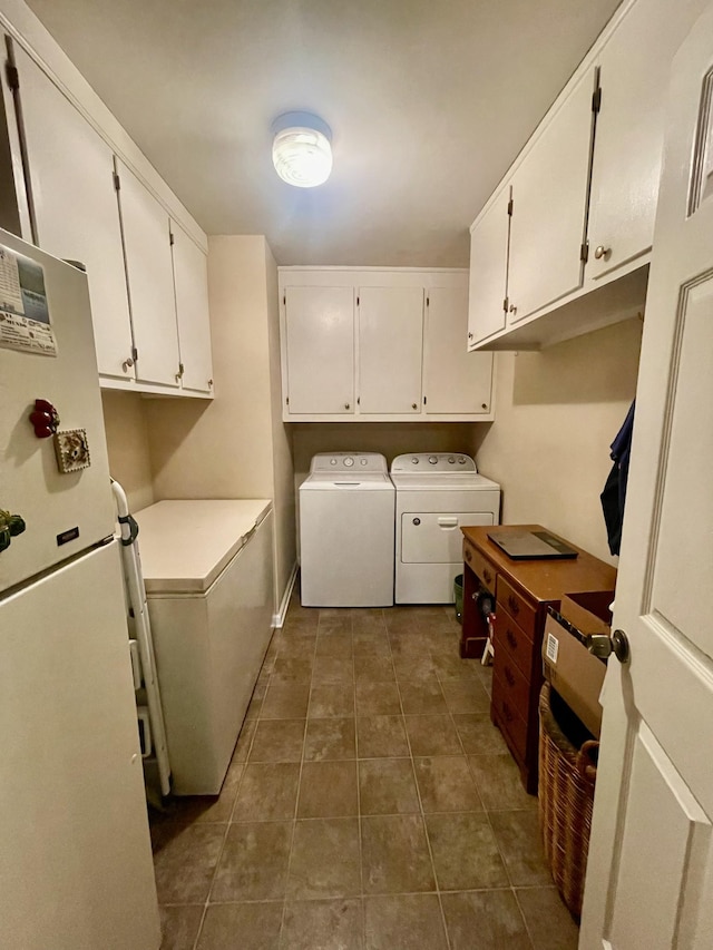 laundry room featuring cabinets, separate washer and dryer, and dark tile patterned flooring