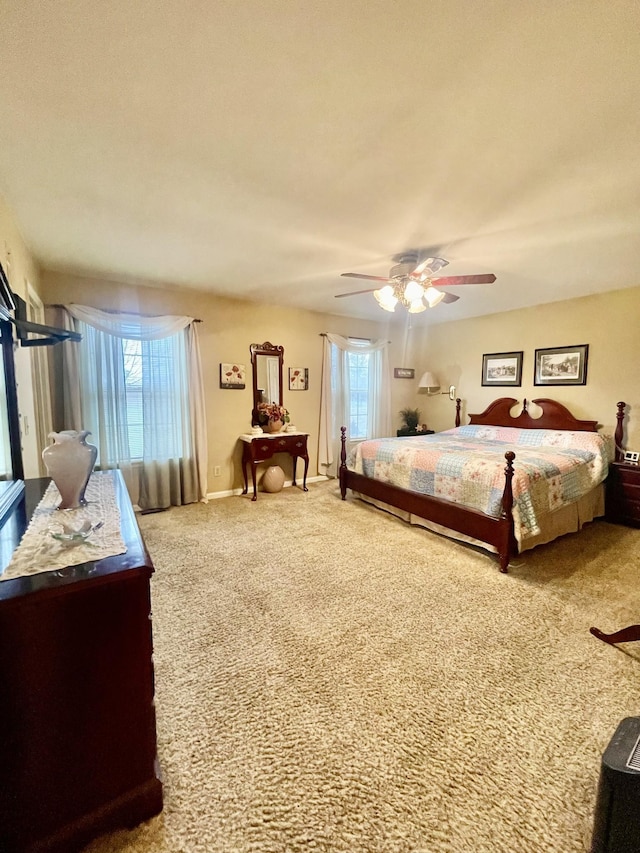 carpeted bedroom featuring multiple windows and ceiling fan