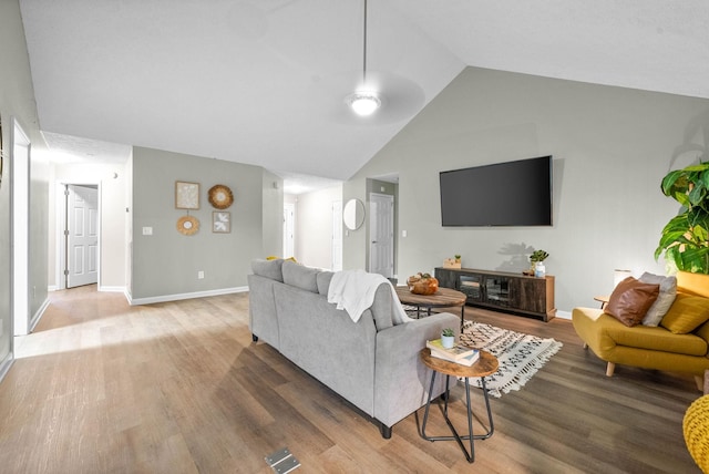 living room with hardwood / wood-style flooring and high vaulted ceiling