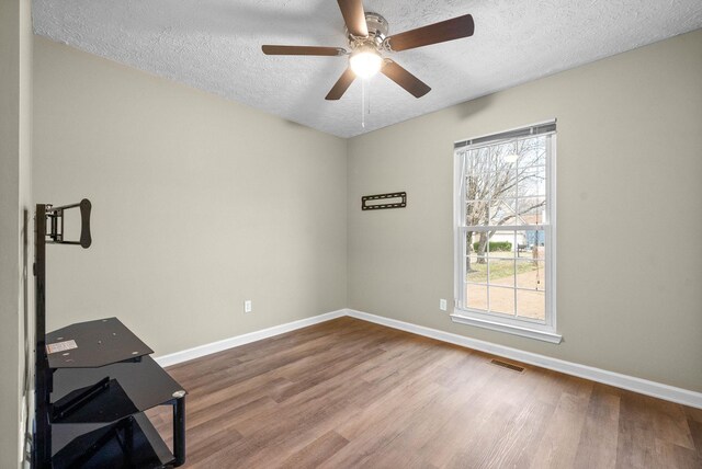 unfurnished room with hardwood / wood-style floors, a textured ceiling, and ceiling fan