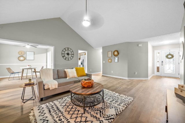 living room featuring ceiling fan, high vaulted ceiling, and light wood-type flooring