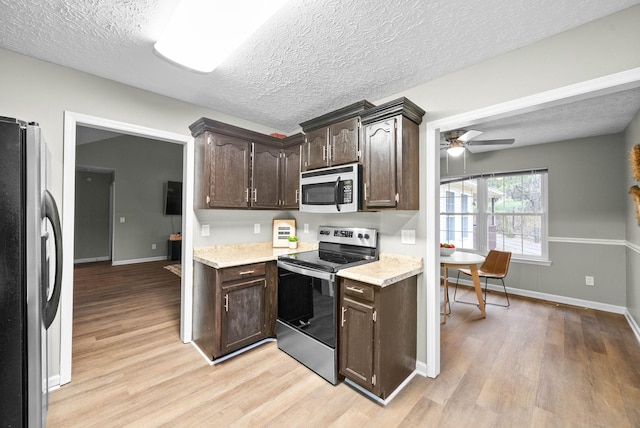 kitchen with light hardwood / wood-style flooring, ceiling fan, appliances with stainless steel finishes, dark brown cabinets, and a textured ceiling