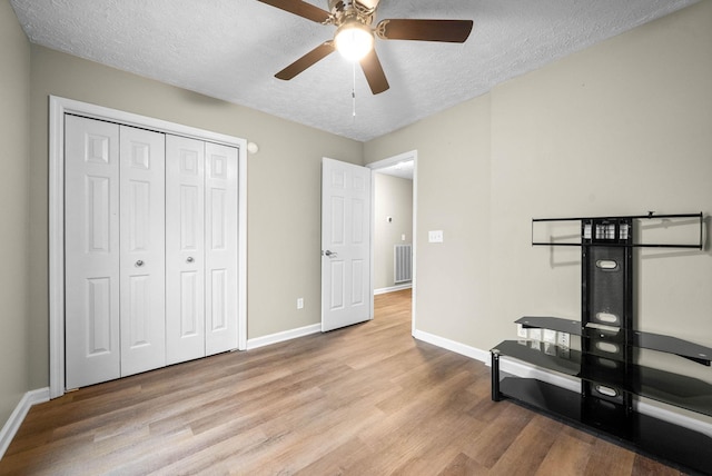 bedroom with a closet, ceiling fan, a textured ceiling, and light hardwood / wood-style flooring