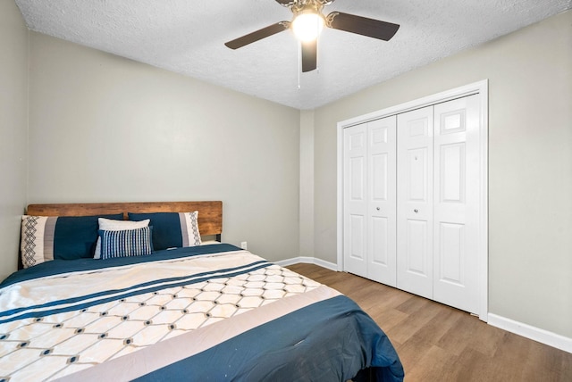 bedroom with hardwood / wood-style floors, a closet, a textured ceiling, and ceiling fan