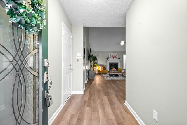 corridor with hardwood / wood-style floors and a textured ceiling