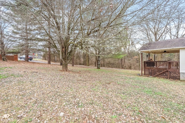 view of yard with a wooden deck and ceiling fan