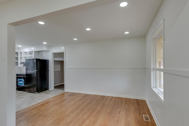 empty room featuring light wood finished floors, baseboards, visible vents, and recessed lighting