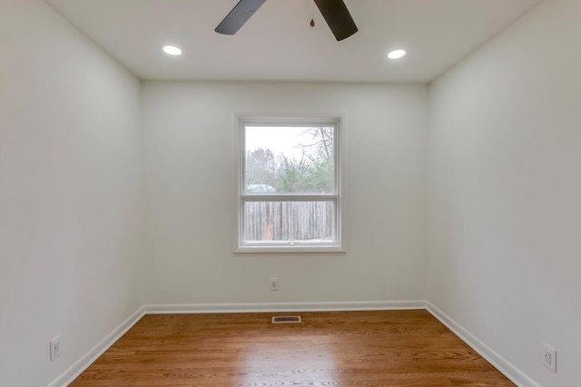 empty room featuring recessed lighting, wood finished floors, visible vents, and baseboards