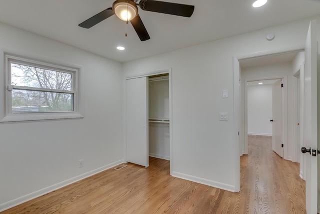 unfurnished bedroom featuring light wood-style floors, a closet, and baseboards