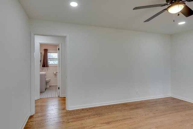 empty room featuring a ceiling fan, light wood-style flooring, and baseboards