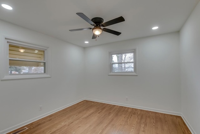 empty room featuring light wood-style floors, recessed lighting, visible vents, and baseboards