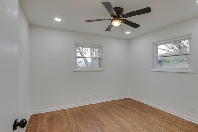 empty room with a healthy amount of sunlight, light wood-style flooring, baseboards, and recessed lighting