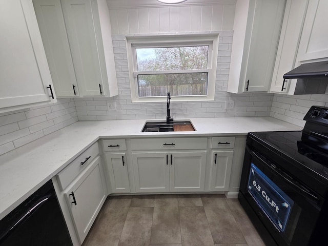 kitchen with decorative backsplash, light stone countertops, black appliances, white cabinetry, and a sink