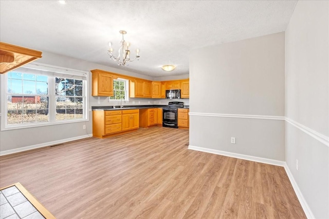 kitchen with sink, an inviting chandelier, black appliances, a textured ceiling, and light wood-type flooring