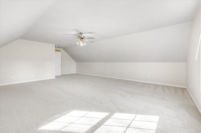 additional living space with light colored carpet, ceiling fan, and vaulted ceiling