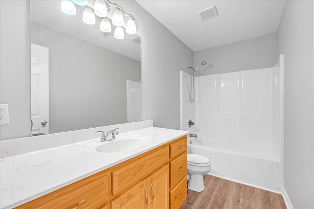 full bathroom with shower / tub combination, vanity, toilet, and hardwood / wood-style floors