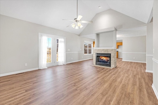 unfurnished living room with high vaulted ceiling, a fireplace, light hardwood / wood-style floors, and ceiling fan