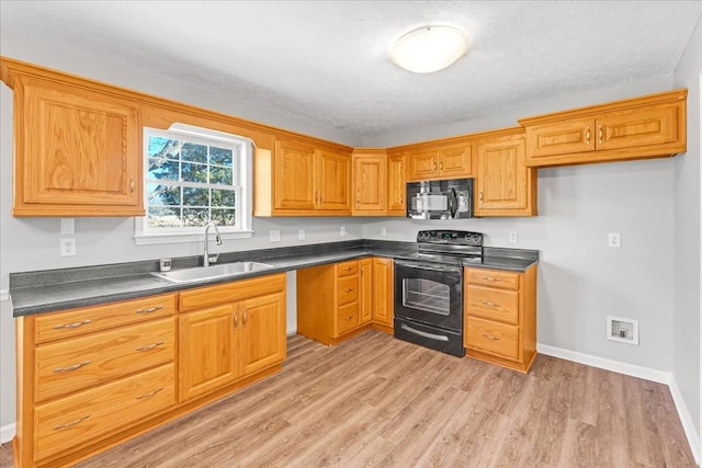 kitchen with light hardwood / wood-style floors, sink, a textured ceiling, and black appliances