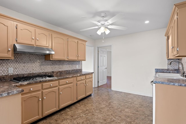 kitchen with sink, backsplash, stainless steel gas stovetop, and ceiling fan