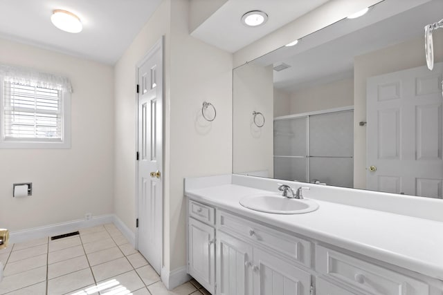 bathroom with vanity, a shower with door, and tile patterned flooring