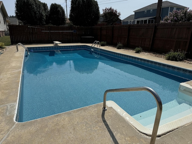 view of swimming pool featuring a diving board