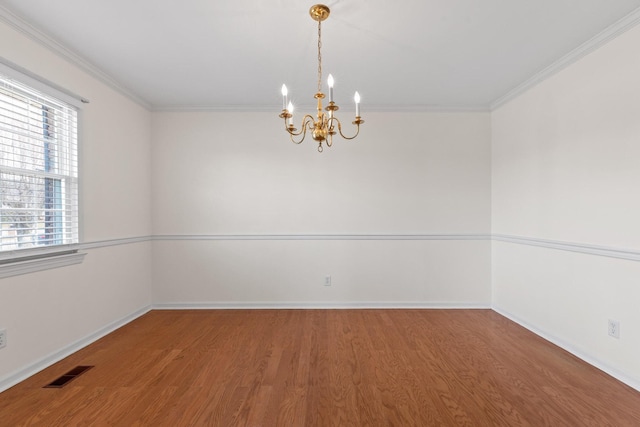 spare room with wood-type flooring, a notable chandelier, and crown molding