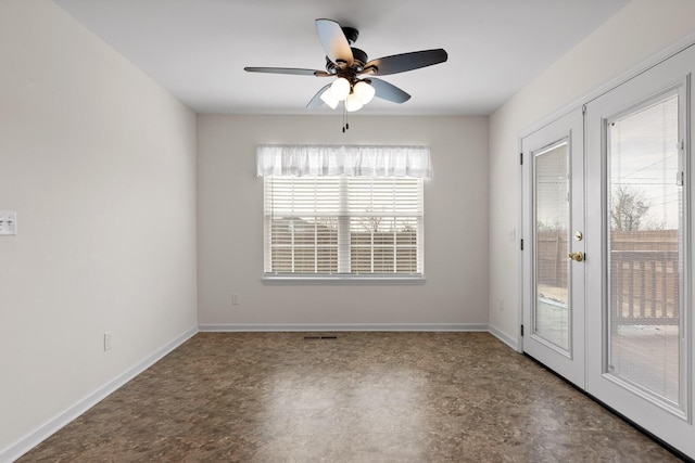 spare room featuring ceiling fan and french doors