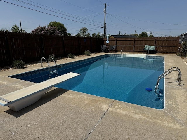 view of pool with a diving board