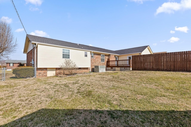 back of house with central AC unit, a yard, and a wooden deck