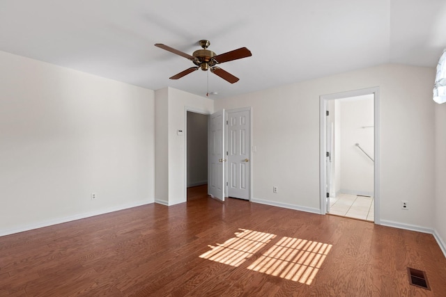 unfurnished bedroom featuring hardwood / wood-style flooring, ensuite bath, and ceiling fan