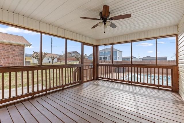 unfurnished sunroom with ceiling fan