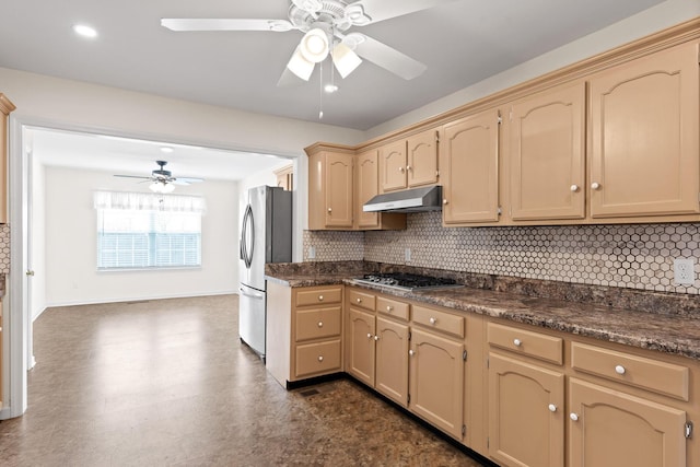 kitchen featuring stainless steel appliances, tasteful backsplash, light brown cabinetry, and ceiling fan