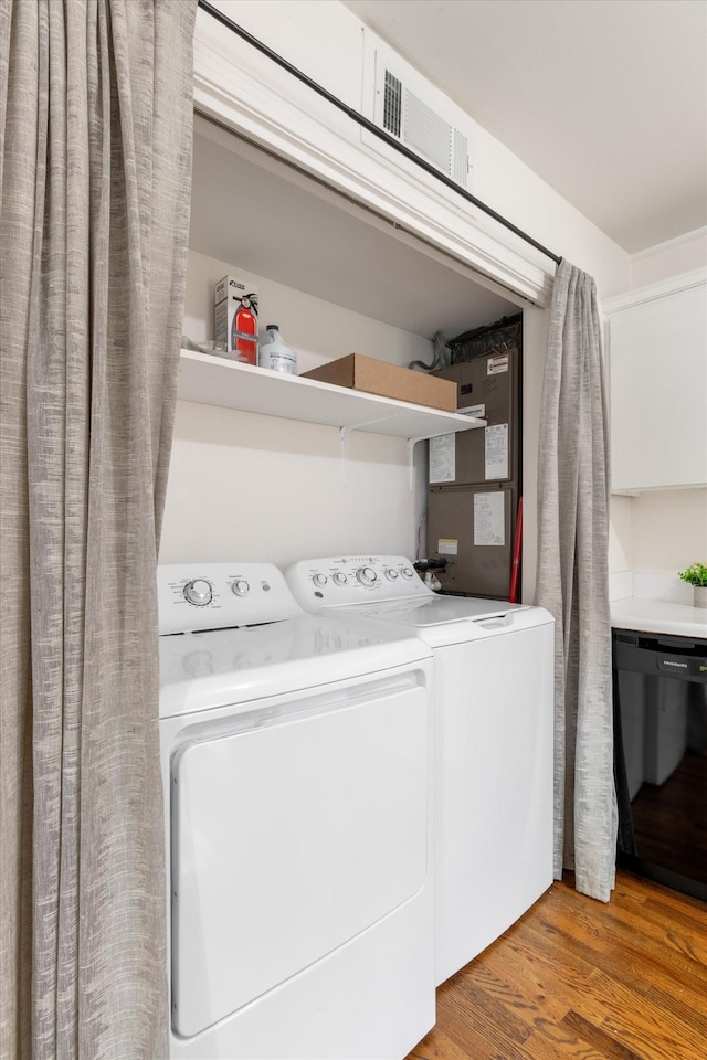 clothes washing area with hardwood / wood-style flooring and independent washer and dryer