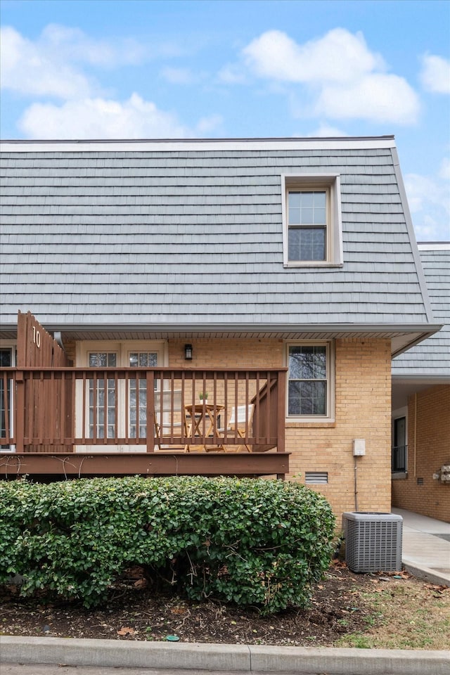 back of property with a wooden deck and central air condition unit