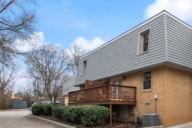 exterior space with central AC unit and a wooden deck