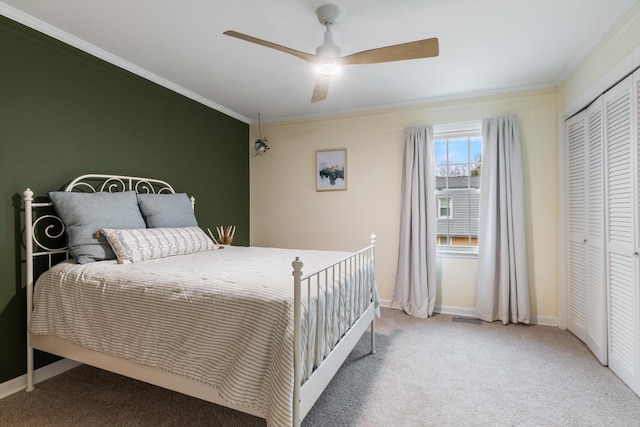 bedroom featuring ornamental molding, carpet, ceiling fan, and a closet