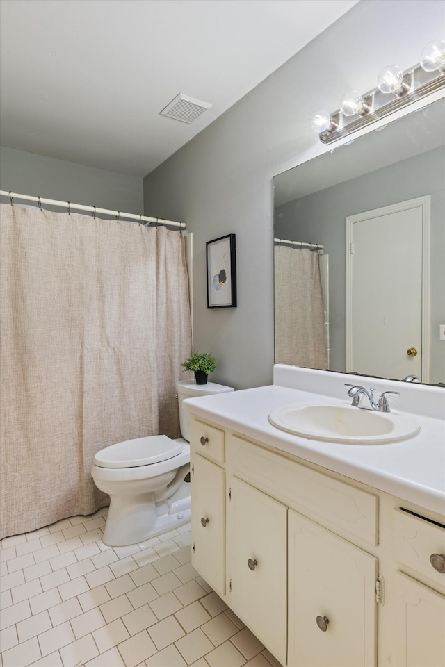 bathroom featuring vanity, tile patterned flooring, and toilet