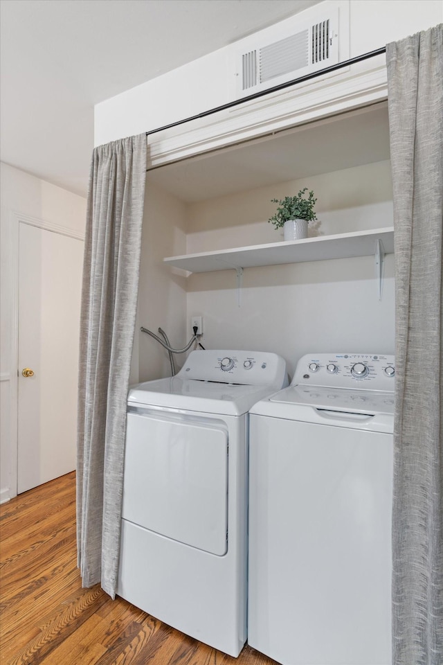 laundry room featuring separate washer and dryer and wood-type flooring