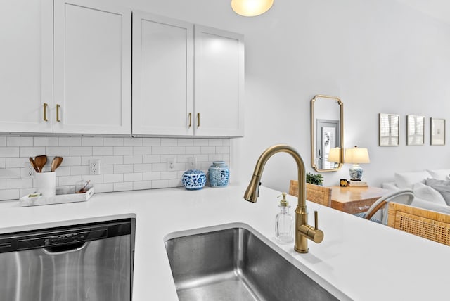 kitchen with white cabinetry, dishwasher, sink, and backsplash