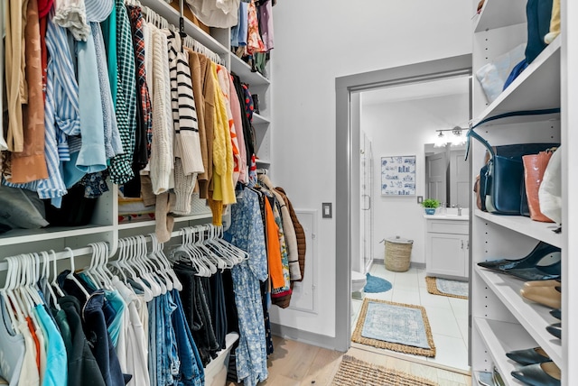 walk in closet featuring sink and light tile patterned floors