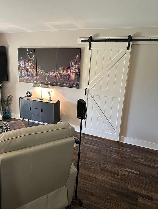 living room featuring a barn door and dark hardwood / wood-style flooring