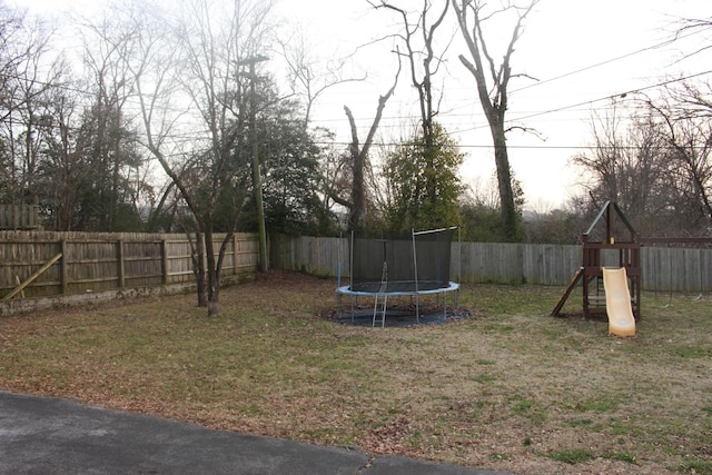 view of yard featuring a playground and a trampoline